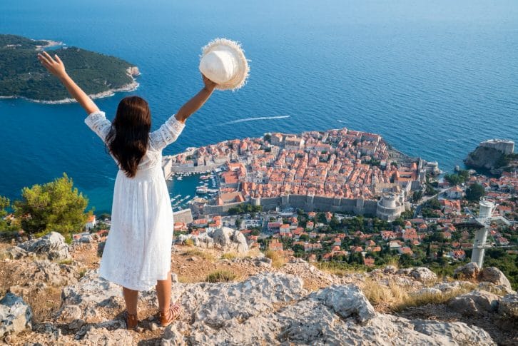 girl with white hat panoramic view of Dubrovnik Croatia