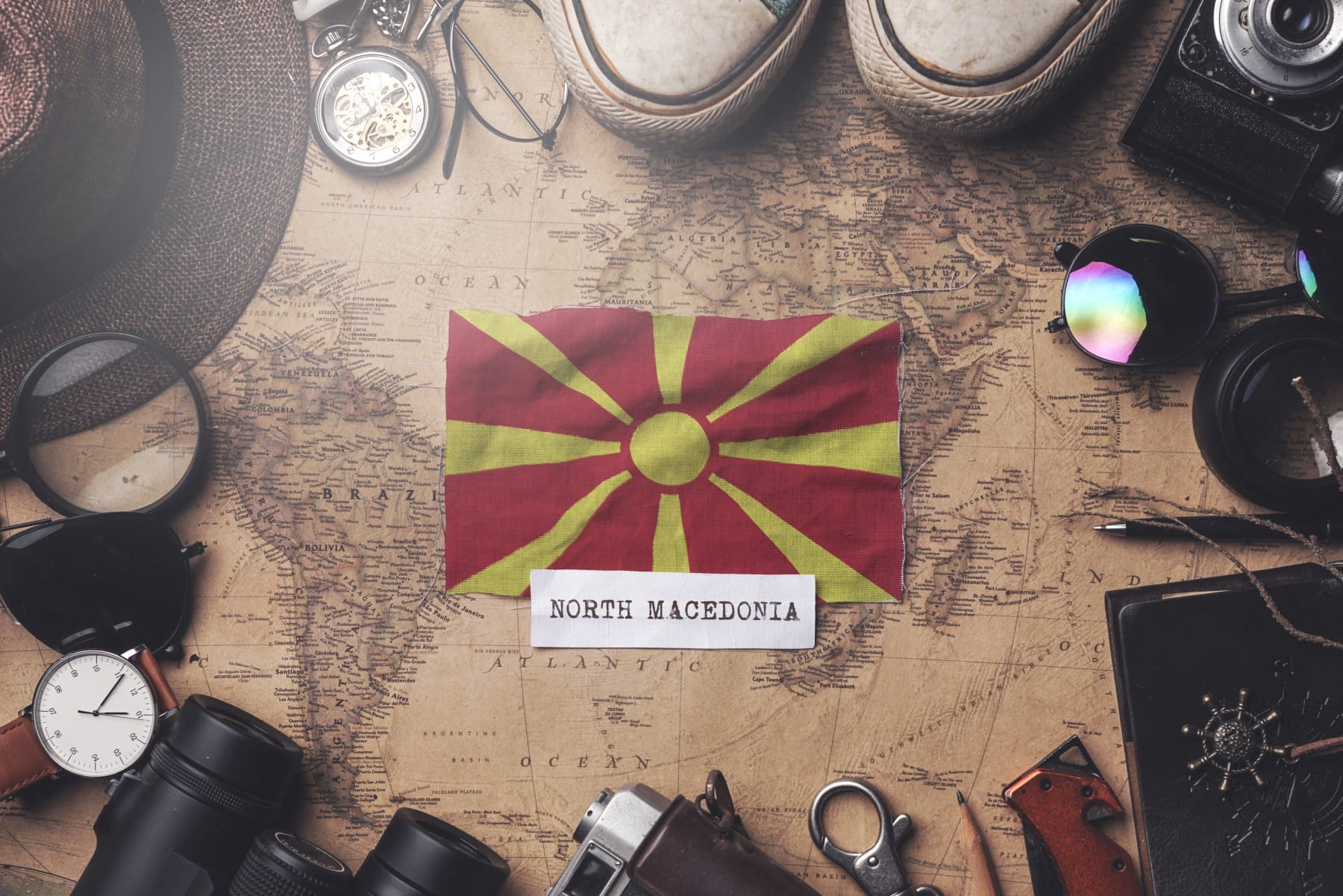 Macedonian flag between traveler's accessories on old vintage map