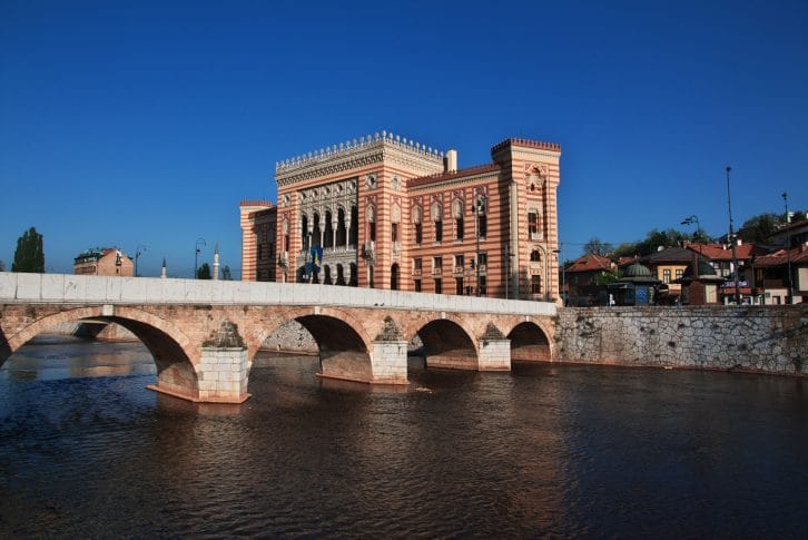 Stone bridge over Miljacka River and Sarajevo City Hall in Sarajevo Bosnia and Herzegovina