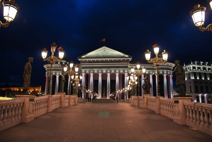 Monuments on Eye Bridge in front of the building of Archeological Museum by night Skopje Macedonia