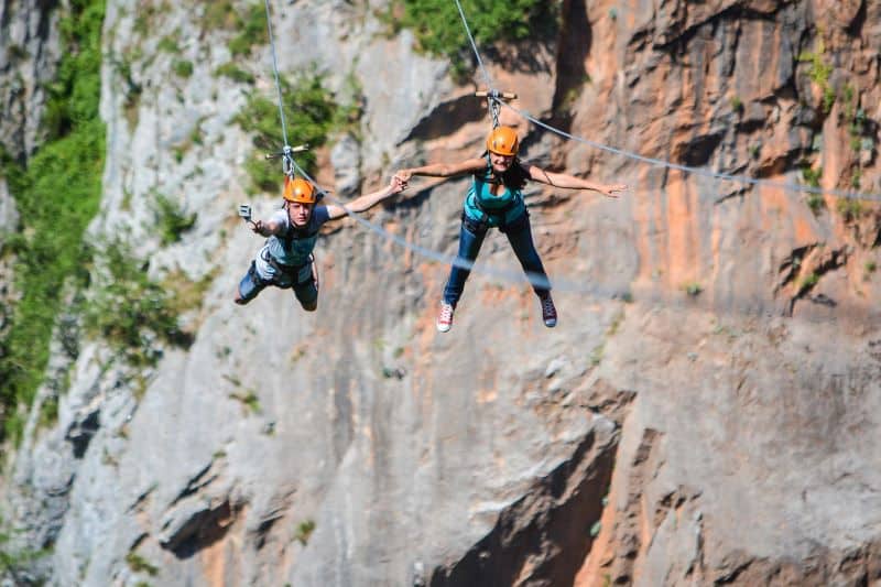 Couple holding hands while zipling, Montenegro