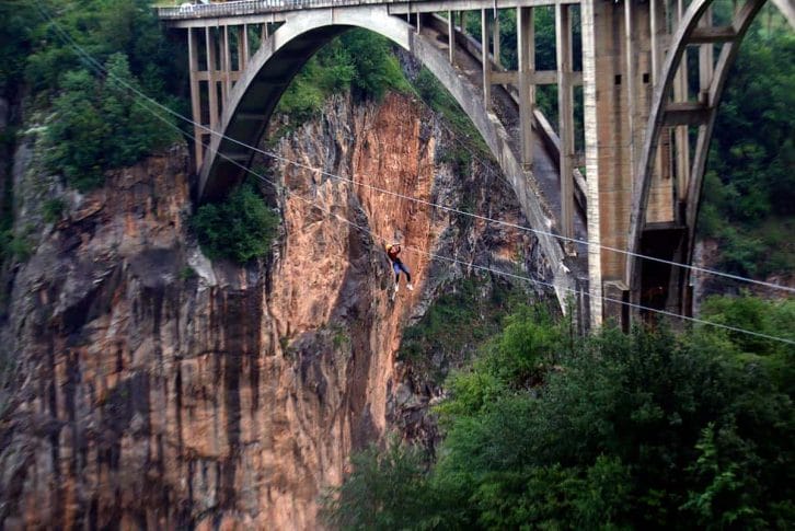 woman-in-jeans-ziplining-next-to-bridge Woman in jeans ziplining next to the bridge
