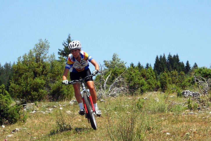Girl biking Kosanica over the mountain