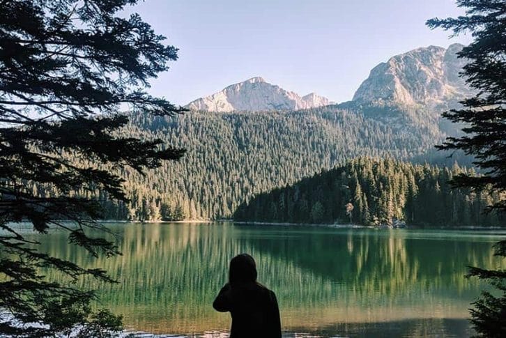 A girl standing Black Lake in Montenegro