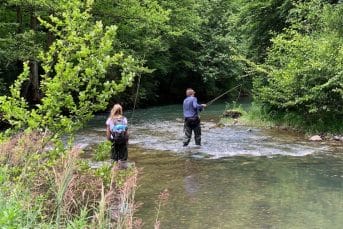 Two people fly fishing in stream on tara river in Montenegro