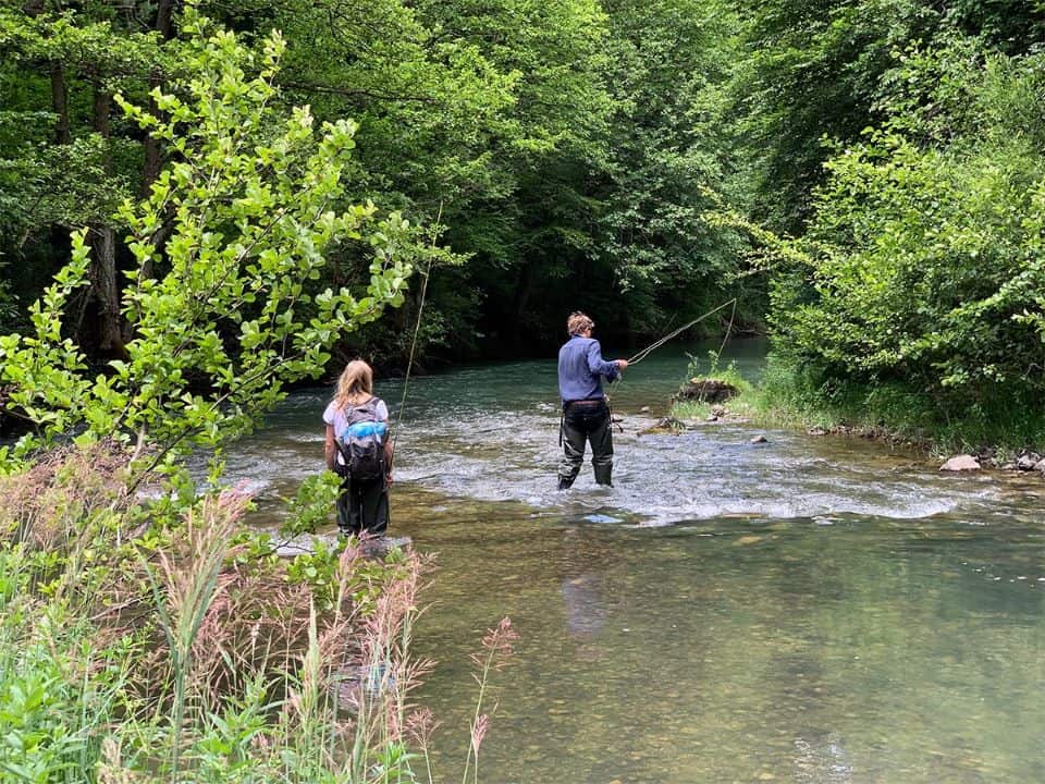 Two people fly fishing in stream on tara river in Montenegro