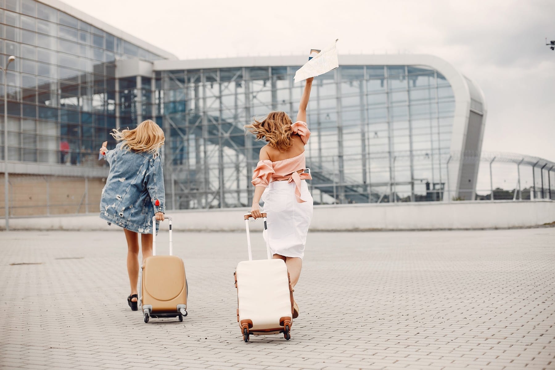 Two beautiful girls standing by the airport