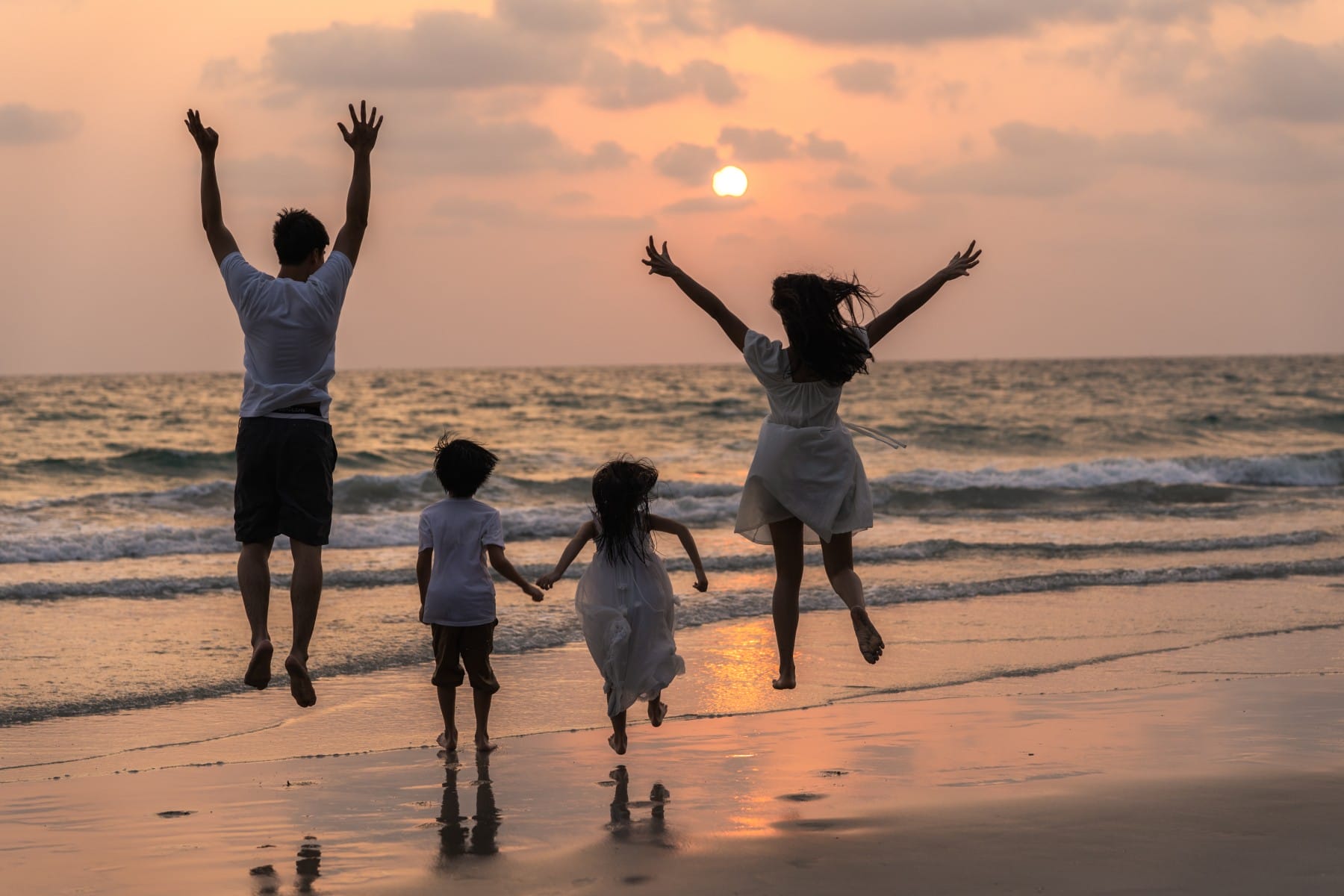 Family jumping on the shore of Adriatic Sea sunset Ulcinj Montenegro