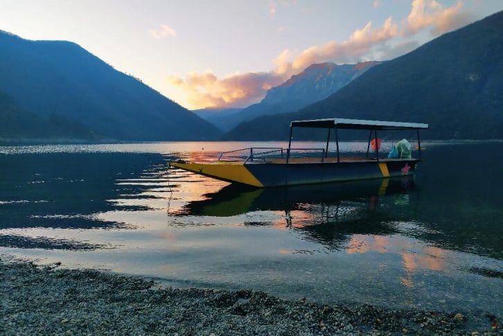 A boat on Piva Lake at sunset