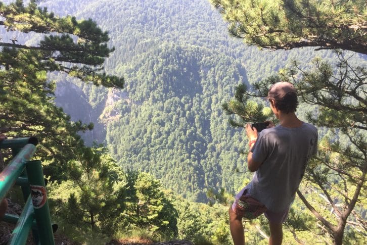 Hiking Trnovacko Lake a guy outside fence photographs waterfall Skakavac