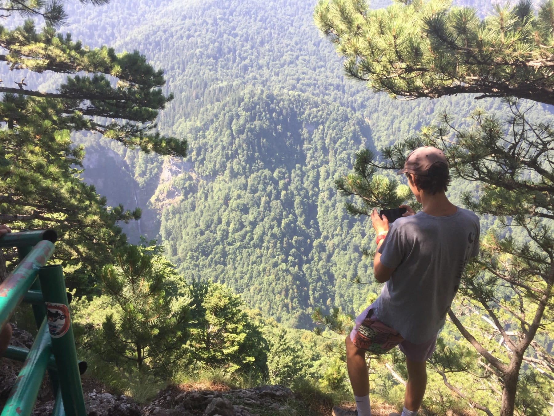 Hiking Trnovacko Lake a guy outside fence photographs waterfall Skakavac