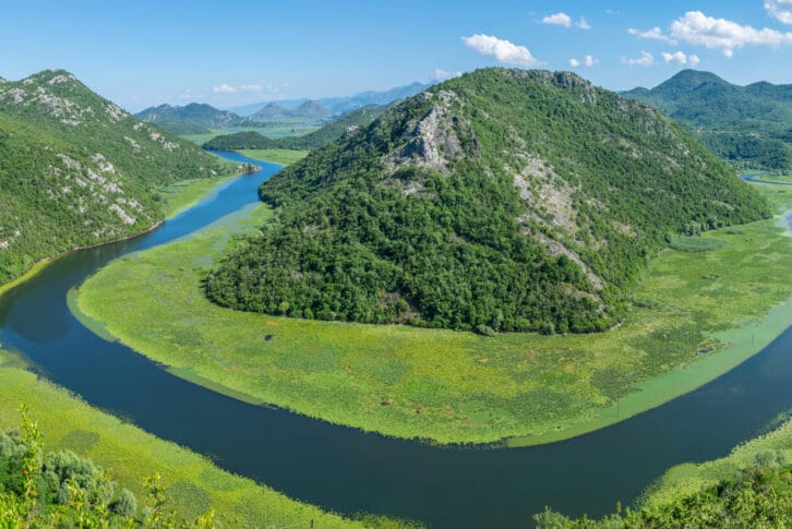 The picturesque meandering river flows among green mountains.