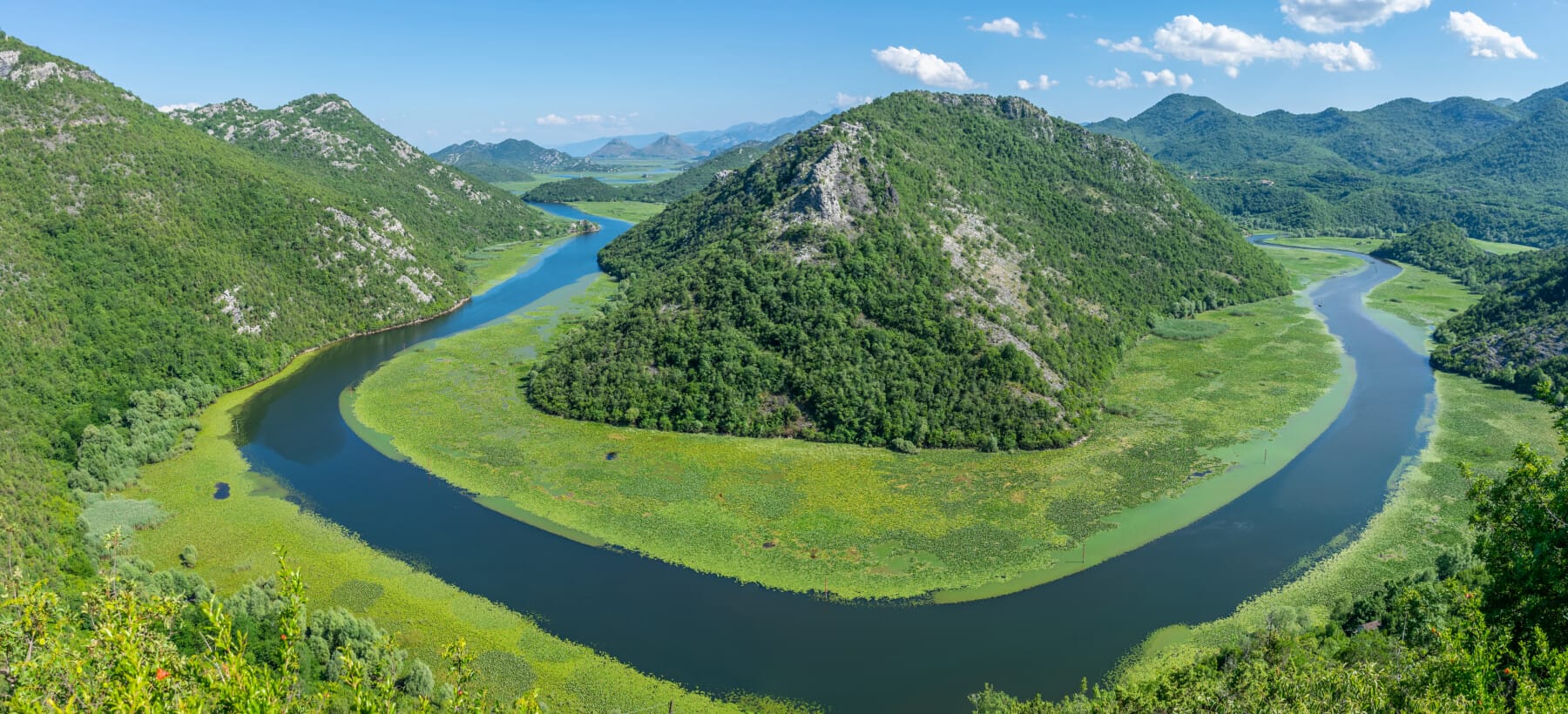 The picturesque meandering river flows among green mountains.