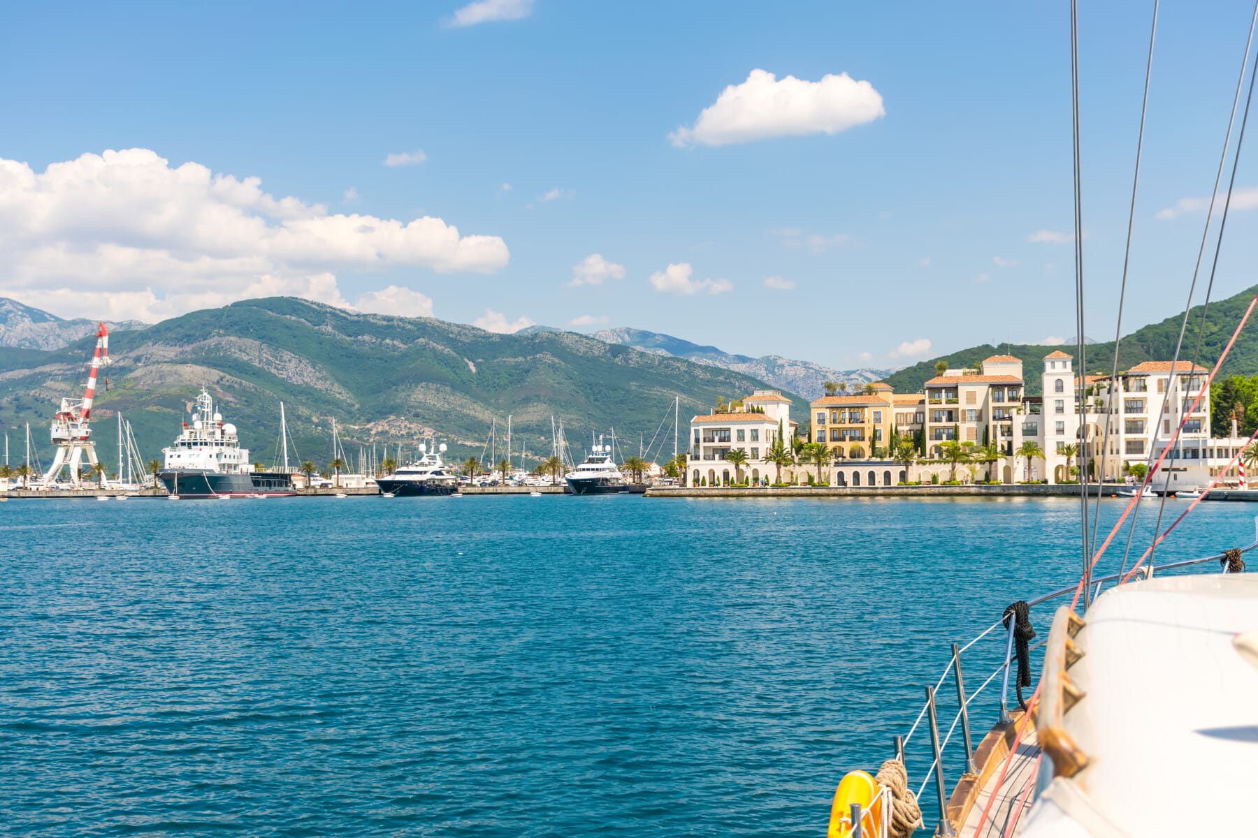 yachts of various sizes and large vessels moored in the port of Tivat.