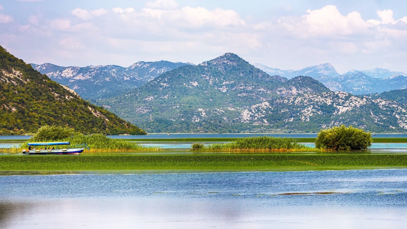 Awesome view of Skadar lake surrounded by green mountain peaks on a sunny day.
