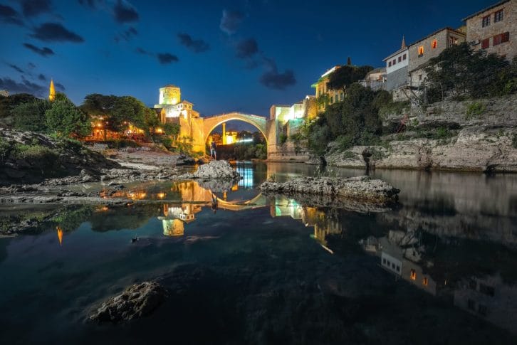 Majestic evening view of Mostar with the Mostar Bridge, houses and minarets, at evening