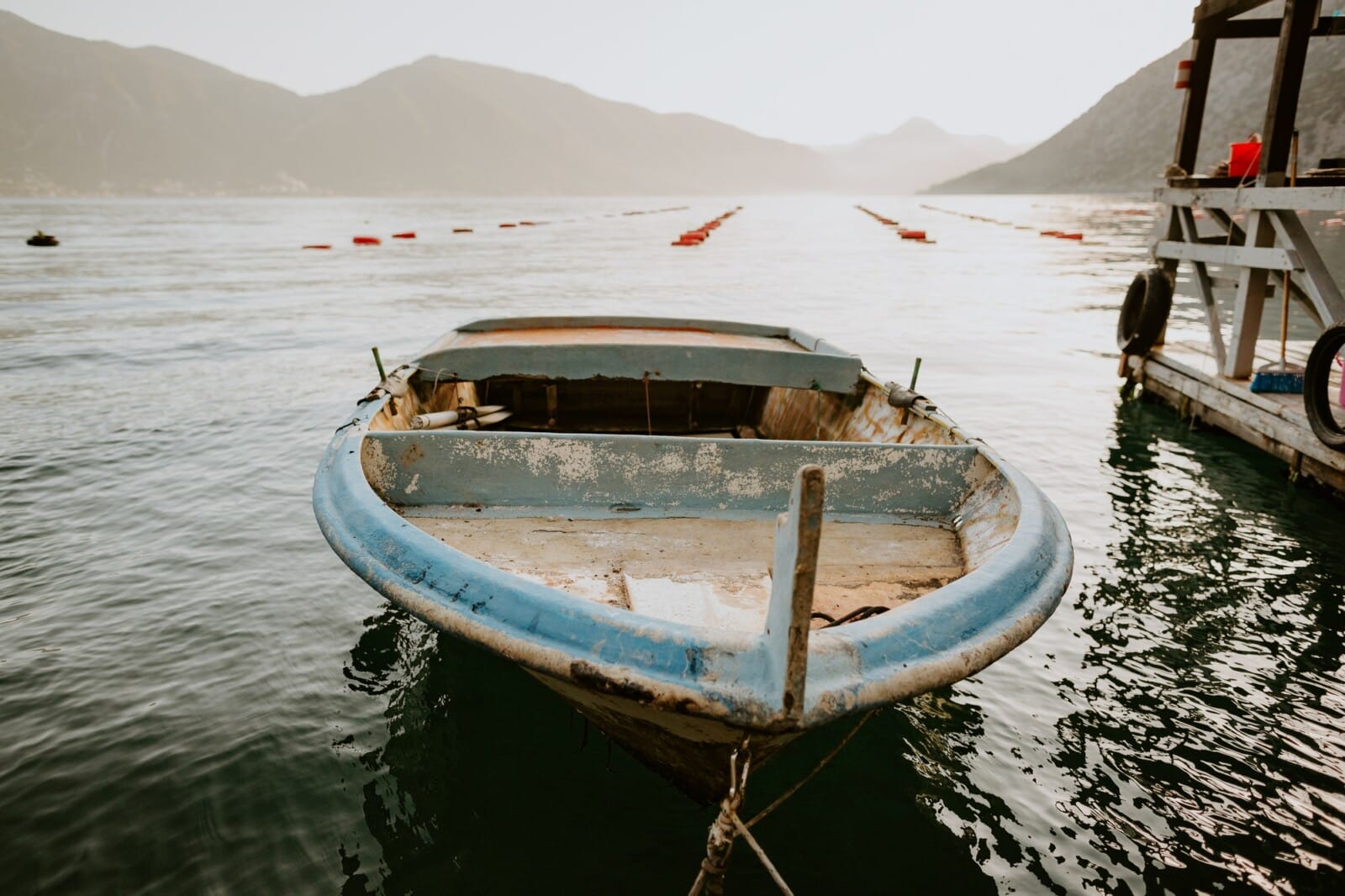 old fisherman boat in sea bay with mountains background