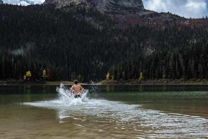Hardening in cold water. Man bathes in the lake autumn in Montenegro, Durmitor Park
